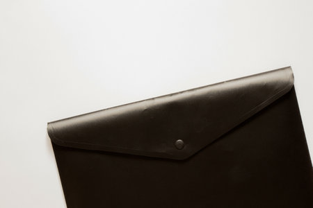 Black business folder with a button as a background for business themes on a white background, documents and office workの写真素材