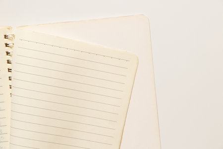 Open spiral notebook with blank lined sheets as background for notes on white background, planning and studyingの写真素材