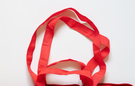 Close-up of red reusable grocery bag handles on white backgroundの写真素材