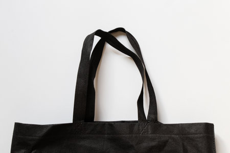 Eco friendly black material bag with long handles on white background, eco-friendly alternative to plastic bagsの写真素材