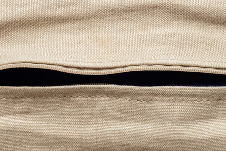 Natural beige linen fabric texture close-up and horizontal zipper, background for design and creativityの写真素材
