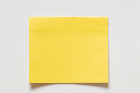 Yellow sticky note on white background for notes as background, reminders, announcements and designer layoutsの写真素材