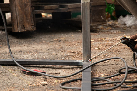 Welding metal parts with sparks and smoke - the work process of a welder joining metal elements with manual weldingの写真素材