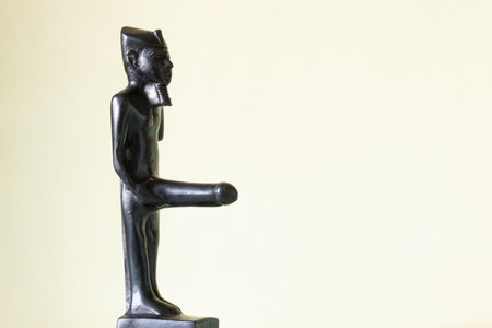 Egyptian god of fertility Min figurine on table on light background as a symbol of faith, family,...