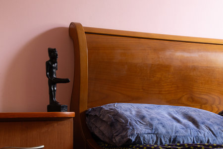 Egyptian god of fertility Min figurine on a bedside table in the bedroom as a symbol of faith, family, religion and home comfortの写真素材