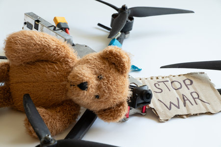 Baby teddy bear and Russian combat drone and paper potato with the inscription stop war on a white background, wars against civiliansの写真素材