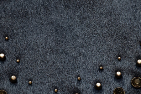 Dark fur with metal decorations, background and texture of black bag close-upの写真素材