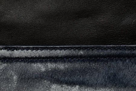 Background of black leather bag worn and frayed close-up, women's leather bagの写真素材