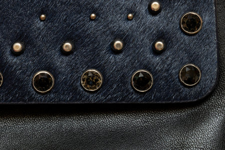 Dark fur with metal decorations, background and texture of black women's bag close-upの写真素材