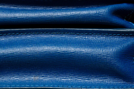 Blue leather textured with seams and folds close-up, women's bagの写真素材
