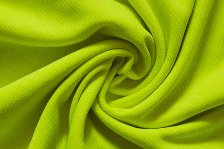 Bright lemon sports fabric twisted in the center as a background for design, close-up of folds, textile patternの写真素材