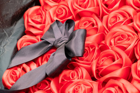 Funeral bouquet of red roses with a black bow lies for offering on the alley of memory, a symbol of grief, memory and respect for the fallen heroesの写真素材