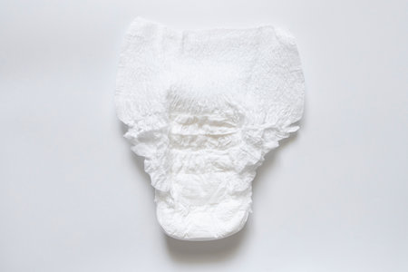 White disposable adult diapers lying on white background and top view of diaperの写真素材