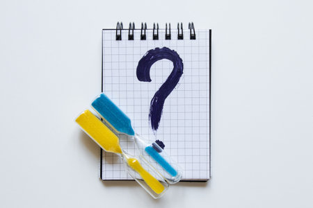 A notebook in a cage with a dark blue question mark drawn on it, next to it an hourglass with yellow...