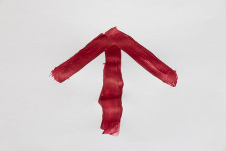 Red arrow drawn with watercolor on white background as forward or up direction, navigation element