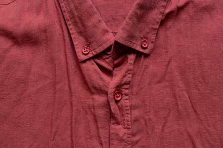 Close-up of a man's red shirt with a collar and buttons in an unfolded state, textile and clothing for style and casual wearの写真素材