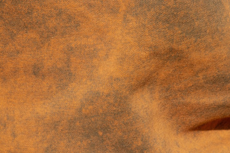 A close-up of a two-tone fabric with a smooth transition of orange and gray shades as a background and textureの写真素材