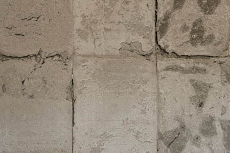 An old concrete wall with uneven surfaces and tile marks, a surface with cracks and chips, related...