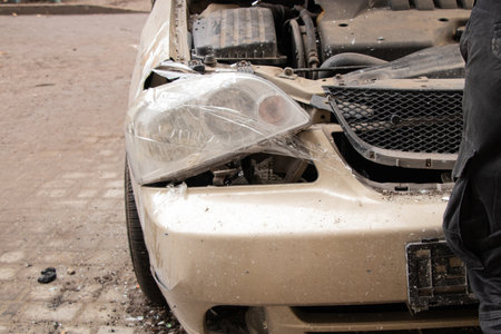 A car damaged by a drone strike near a residential building and a car damaged by shockwavesの写真素材