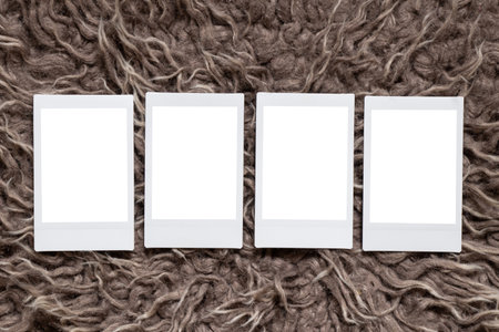 A blank white template with four instant photo-style photos lying on a brown hairy carpet is used as...