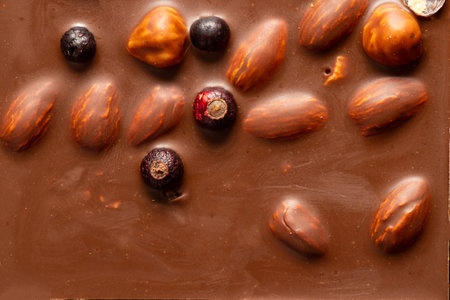 Milk chocolate bar with almonds, hazelnuts, and whole berries, sweet dessert texture and natural...