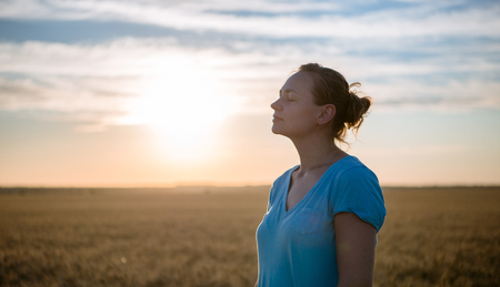 Free Happy Woman Enjoying Nature and Freedom Outdoor. Woman with arms outstretched in a wheat field in sunset.の写真素材