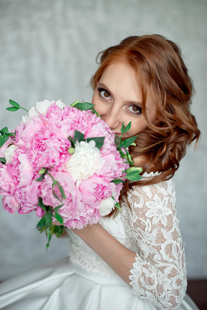 Portrait of beautiful red-haired girl holding bouquet.の写真素材