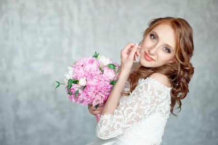 Portrait of beautiful red-haired girl holding bouquet.の写真素材