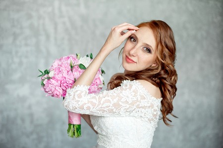 Portrait of beautiful red-haired girl holding bouquet.の写真素材