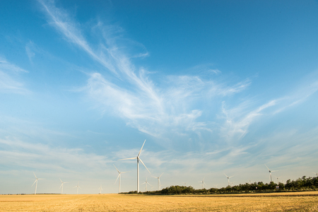 Wind turbine - renewable energy source. Wild mill in field with blue sky. Power and energy.の写真素材