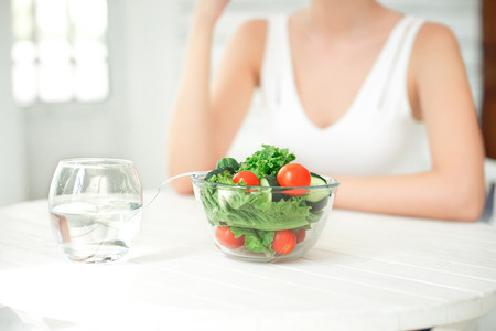 Beautiful fit woman eating healthy salad.の写真素材