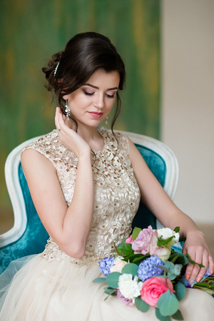 Image of elegant girl sitting in retro style armchair. Brunette young model.の写真素材