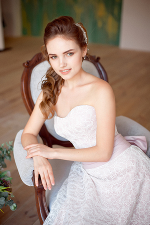 Portrait of a fashionable model sitting in a chair in Art Nouveau styleの写真素材