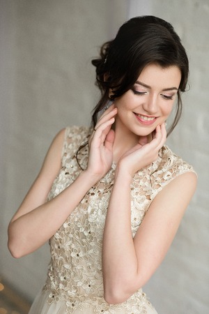 Half length portrait of brunette smiling woman dressed in sleeveless light evening dressの写真素材