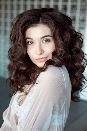 Close up portrait of a young curly girl with medium-brown hair.の写真素材