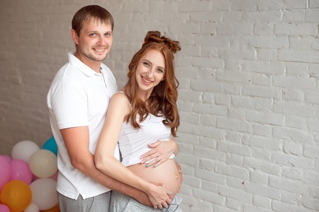Pregnant woman and husband holding hands on the belly.の写真素材