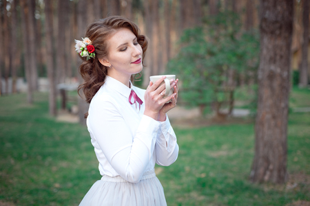 Happy woman holding cup of tea outdoor.の写真素材