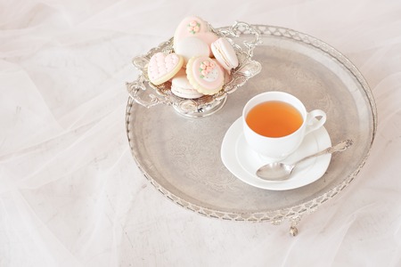 silver tray with cup of tea and macaroons top viewの写真素材