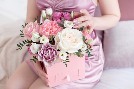 Young dreaming woman holding Square Pink Flower box with Fresh Rose and candiesの写真素材