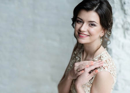 Half length portrait of brunette smiling woman dressed in sleeveless light evening dressの写真素材