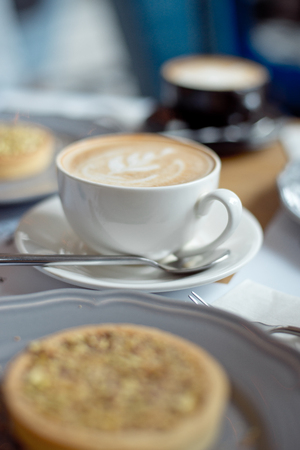 close-up cup of coffee with pistachio tart on the table.の写真素材