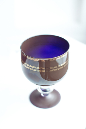 A vintage brown crystal wine glass on wooden table. Brown crystal goblet on the legの写真素材
