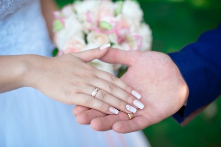 Close-up Bride and grooms hands with wedding ringsの写真素材