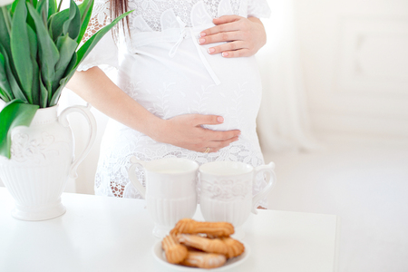 Close-up pregnant woman in white room.の写真素材