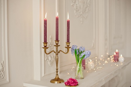 candlesticks on fireplace in white room with baroque interiorの写真素材