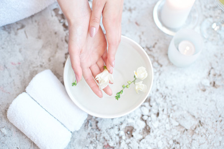 Woman In Beauty Salon Holding Hands In Aroma Bath Before Spa Procedureの写真素材