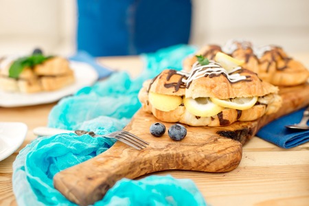 Close-up chef decorating sweet croissant on cooking table.の写真素材