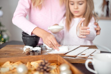 Two sisters with blond hair make cookies in the kitchen. New Years, holiday, Christmas conceptの写真素材