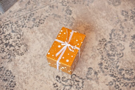 Gift box on white background. Present in craft and colored paper decorated with white satin ribbon...