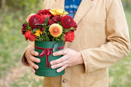 Close-up flower-box in man hands as a gift concept for wedding, birthday, event, celebration, flowers delivery, surpriseの写真素材